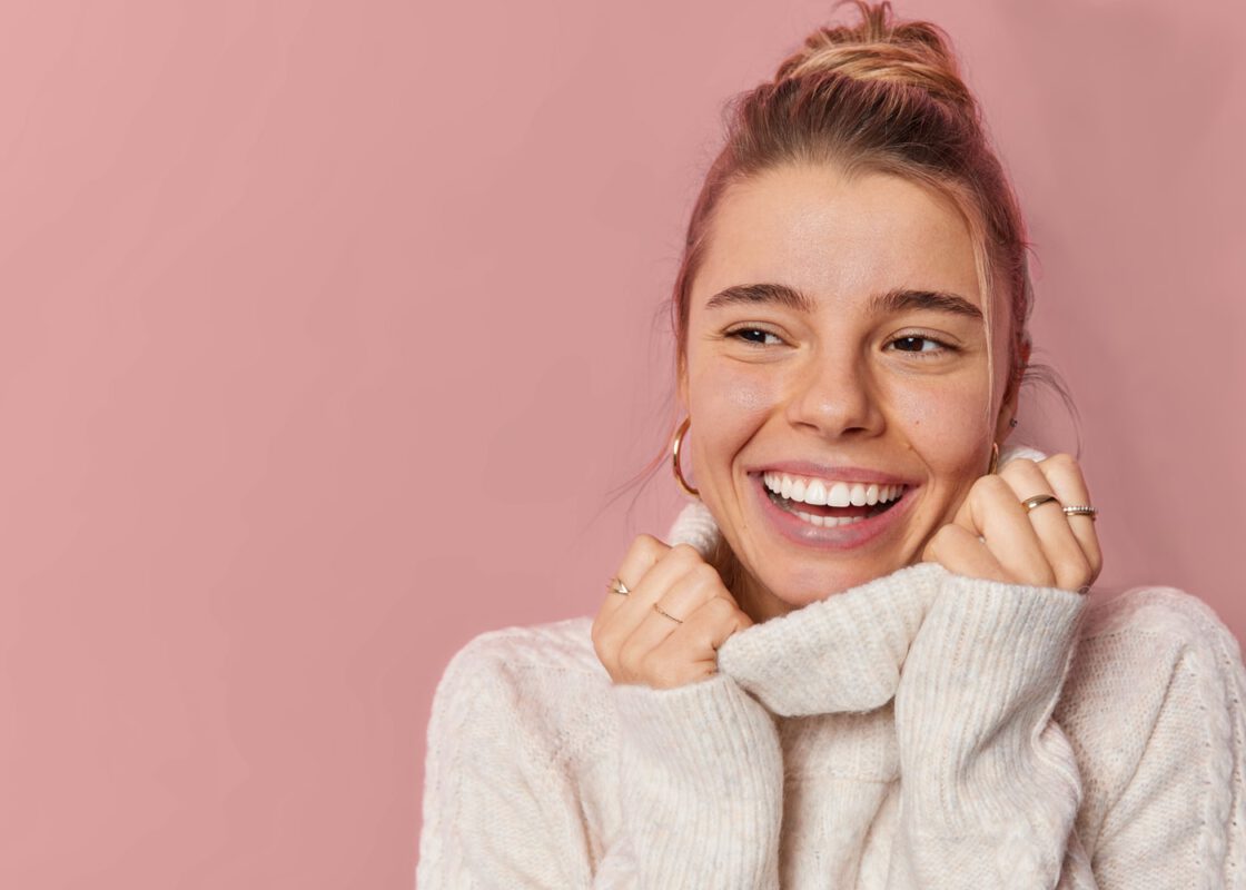 A women in a sweater wearing jewelry